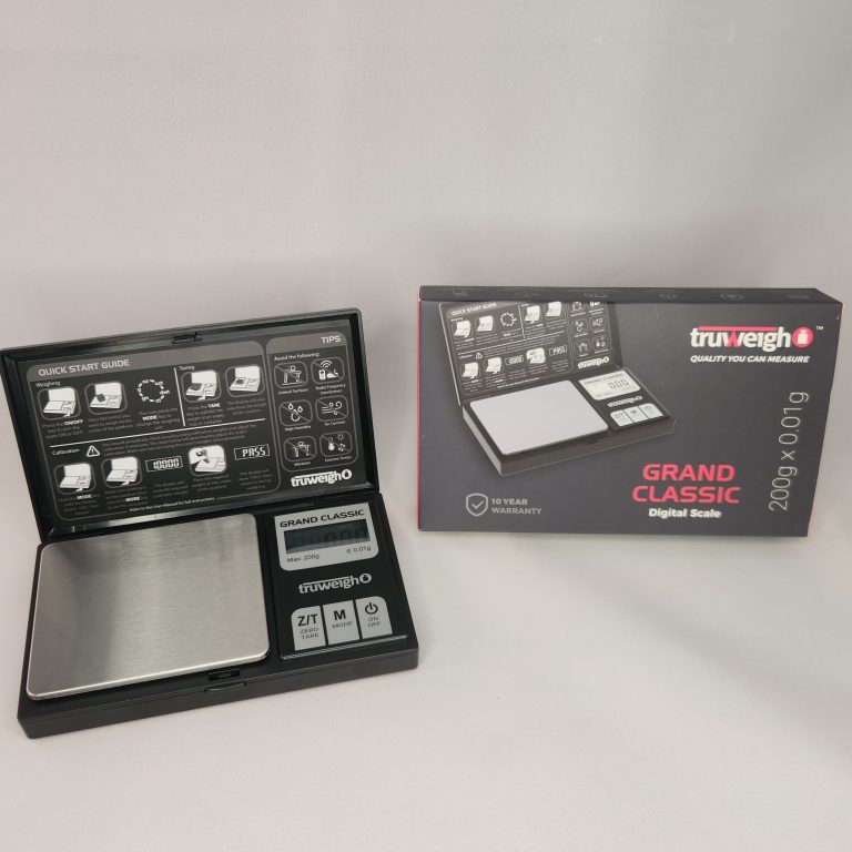 Black Truweigh Grand Classic Digital Scale - 200g x 0.01g Next to its original packaging against a white background.