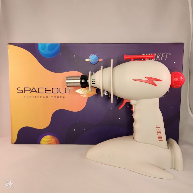 BUTANE TORCH IN FRONT OF DECORATED BOX LISTED THICKET LIGHTYEAR SPACED OUT BLOW TORCH WHITE BACKGROUND